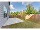 Large, grassy backyard with a concrete patio and wooden fence, perfect for outdoor activities at 2316 Hastings Manor Ln, Hampton, GA 30228