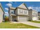 Charming two-story home featuring a gray exterior, attached garage, and well-maintained front lawn at 2316 Hastings Manor Ln, Hampton, GA 30228