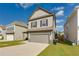 Two-story home with a gray exterior, a well-manicured lawn, and an attached garage at 2316 Hastings Manor Ln, Hampton, GA 30228