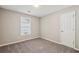 This cozy bedroom has neutral walls and carpet, one window with blinds and a standard closet door at 4805 Diggers Way, Sugar Hill, GA 30518