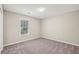 Clean bedroom with neutral walls and carpet, a window overlooking the yard, and a standard closet at 4805 Diggers Way, Sugar Hill, GA 30518