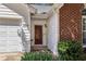 A close-up view of the house number, white siding, and a red brick wall by the front door at 4805 Diggers Way, Sugar Hill, GA 30518