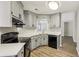 The kitchen features black appliances, plenty of cabinet space, and wood-look flooring at 4805 Diggers Way, Sugar Hill, GA 30518