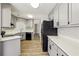 An open-concept kitchen features grey cabinets, stainless steel appliances, and wood-look flooring at 4805 Diggers Way, Sugar Hill, GA 30518