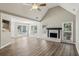 Open-concept living room featuring wood floors, fireplace, large windows, and vaulted ceilings at 4805 Diggers Way, Sugar Hill, GA 30518