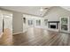 Open-concept living room featuring wood floors, a fireplace, large windows, and vaulted ceilings at 4805 Diggers Way, Sugar Hill, GA 30518