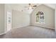 A large main bedroom with vaulted ceilings, neutral carpet and a bright, arched window at 4805 Diggers Way, Sugar Hill, GA 30518