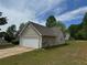 Residential home with an attached two-car garage, vinyl siding, and a paved driveway on a grassy lot at 10111 Commons Way, Jonesboro, GA 30238