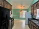 Functional kitchen features dark wood cabinetry, black appliances, linoleum flooring, and a dining area at 10111 Commons Way, Jonesboro, GA 30238