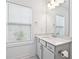 Bright bathroom features a white vanity with marble countertop, modern fixtures, and a large window for natural light at 1329 Bennett Creek Ovlk, Suwanee, GA 30024
