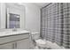 Clean bathroom features a bathtub with modern toilet and vanity, light tile flooring, and striped shower curtain at 1329 Bennett Creek Ovlk, Suwanee, GA 30024