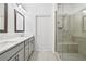 Bright bathroom with double sinks, quartz countertops, framed mirrors, and a glass-enclosed shower with a bench at 1329 Bennett Creek Ovlk, Suwanee, GA 30024