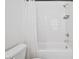 Modern bathroom features a white tub with a shower, white subway tile, dark hardware and fixtures, and a toilet at 1329 Bennett Creek Ovlk, Suwanee, GA 30024
