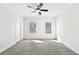Spacious bedroom featuring neutral walls and carpet, with a ceiling fan and two windows at 1329 Bennett Creek Ovlk, Suwanee, GA 30024