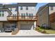 Three-story townhouse features wood decks, neutral color scheme, basement garage, and manicured landscaping at 1329 Bennett Creek Ovlk, Suwanee, GA 30024