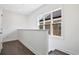 Well lit hallway with dark hardwood floors and a window, and a door at 1329 Bennett Creek Ovlk, Suwanee, GA 30024