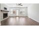 A cozy living room features a decorative fireplace, hardwood flooring, and a ceiling fan at 1329 Bennett Creek Ovlk, Suwanee, GA 30024