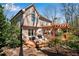 Rear exterior of tan home with a wood pergola over a deck surrounded by mature trees at 1548 Valley Reserve Nw Ct, Kennesaw, GA 30152