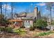 Charming home exterior featuring a wooden pergola, lush landscaping, and large windows at 1548 Valley Reserve Nw Ct, Kennesaw, GA 30152