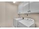 Practical laundry room featuring washer, dryer, and white cabinets for ample storage at 1548 Valley Reserve Nw Ct, Kennesaw, GA 30152
