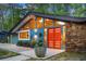 A unique home with a modern design featuring a stone accent wall and vibrant orange double-door entry at 2895 Dunnington Cir, Atlanta, GA 30341