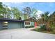 Charming blue single-story home with modern architectural details, attached garage, and inviting orange front door at 2895 Dunnington Cir, Atlanta, GA 30341