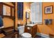 Stylish half bathroom with orange walls, tiled floor, and vintage fixtures at 462 N Highland Ave, Atlanta, GA 30307