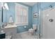 Bright bathroom featuring blue walls, white fixtures, and a glass-enclosed shower at 462 N Highland Ave, Atlanta, GA 30307