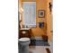 Stylish half bathroom with orange walls, tiled floor, and vintage fixtures at 462 N Highland Ave, Atlanta, GA 30307