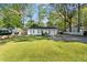 Cozy single-story home surrounded by mature trees, featuring a well-kept lawn and driveway at 5573 Singleton Rd, Norcross, GA 30093