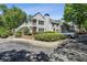 Exterior view of home featuring mature landscaping, a stairway leading to upper level units, and ample parking at 908 Hollyfax Cir, Sandy Springs, GA 30328