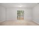 Finished basement area with neutral carpet, a sliding glass door to the outside, and ample natural light at 1728 Devon Sw Dr, Atlanta, GA 30311