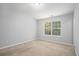 Cozy bedroom with neutral carpet, large window offering views, providing a comfortable and inviting retreat at 1728 Devon Sw Dr, Atlanta, GA 30311