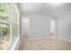 Bright bedroom with neutral carpet, large window, and convenient access to a walk-in closet and ensuite bathroom at 1728 Devon Sw Dr, Atlanta, GA 30311