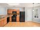 Bright kitchen with wood cabinets, black appliances, granite countertops, and hardwood floors, creating a delightful cooking experience at 1728 Devon Sw Dr, Atlanta, GA 30311