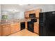 Well-lit kitchen featuring wood cabinets, granite countertops, black appliances, and hardwood floors, creating a welcoming atmosphere at 1728 Devon Sw Dr, Atlanta, GA 30311