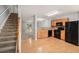 Open kitchen featuring wood cabinets, granite countertops, and black appliances, blending seamlessly with the adjacent living space at 1728 Devon Sw Dr, Atlanta, GA 30311