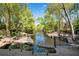 Expansive backyard with a waterfall feature, mature trees, wrought iron fencing, and waterfront access at 2750 Interlaken Dr, Marietta, GA 30062