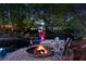 A cozy backyard fire pit and chairs overlook the peaceful lake and dock at dusk at 2750 Interlaken Dr, Marietta, GA 30062