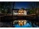 Stunning exterior view of a modern home reflected in a tranquil pond at night at 2750 Interlaken Dr, Marietta, GA 30062