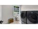 Bright laundry room with tiled floor, a large window and dark, modern washer and dryer at 2750 Interlaken Dr, Marietta, GA 30062
