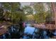Backyard pond at dusk with decorative fountain, dock, fire pit, and lush trees provides a tranquil retreat at 2750 Interlaken Dr, Marietta, GA 30062