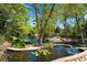 Lush backyard with a stone lined pond and bridge leading to a seating area by the lake at 2750 Interlaken Dr, Marietta, GA 30062