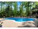 Inviting backyard pool with a brick patio, lounge chairs, mature trees, and wrought iron fencing at 2750 Interlaken Dr, Marietta, GA 30062