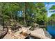 Scenic backyard with a rock waterfall, water feature, mature trees, and waterfront view at 2750 Interlaken Dr, Marietta, GA 30062