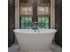 Elegant soaking tub with a sleek faucet, set against a backdrop of natural light and dark trim at 2979 Ridgewood Nw Rd, Atlanta, GA 30327
