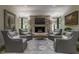 Inviting living room with custom seating, stone fireplace, and oversized windows showcasing the home's style and charm at 2979 Ridgewood Nw Rd, Atlanta, GA 30327