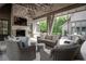 Covered outdoor living space with stone fireplace, comfortable seating, and a view of the lush backyard at 2979 Ridgewood Nw Rd, Atlanta, GA 30327
