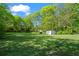 Spacious backyard with lush lawn, storage shed, and mature trees, perfect for outdoor activities at 363 Arnold Mill Rd, Woodstock, GA 30188