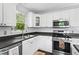 Bright kitchen features white cabinets, stainless steel appliances, and a double sink under a window at 363 Arnold Mill Rd, Woodstock, GA 30188